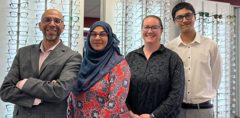 The team at Feltham Eyecare Centre stood in front of their eyewear display in the practice