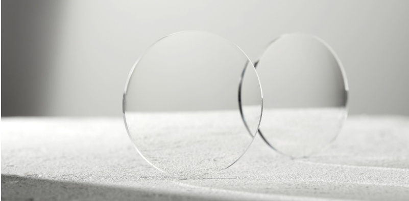 Two spectacle lenses side by side, in a clean, white environment